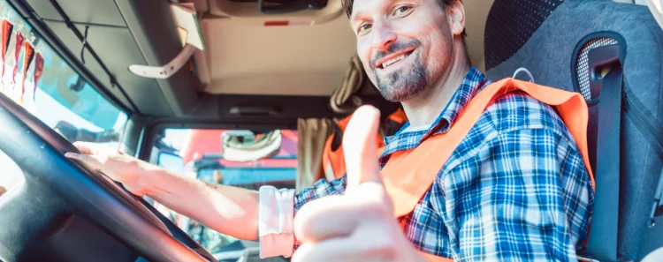 Berufskraftfahrer sitzt im LKW und ist zufrieden mit der Schulung Modul 1 Eco Training bei der Prüfstelle Dahlenburg