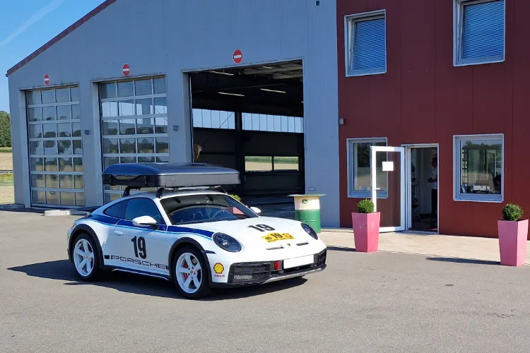 Porsche steht vor dem offenen Rolltor der GTÜ Prüfstelle in Dahlenburg