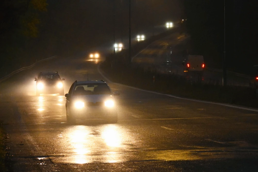 Fahrzeuge fahren in der Nacht auf der Autobahn mit eingeschlteter Beleuchtung