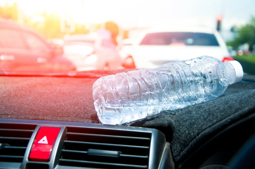 Sommerhitze im Fahrzeug mit Wasserflasche auf der Armatur